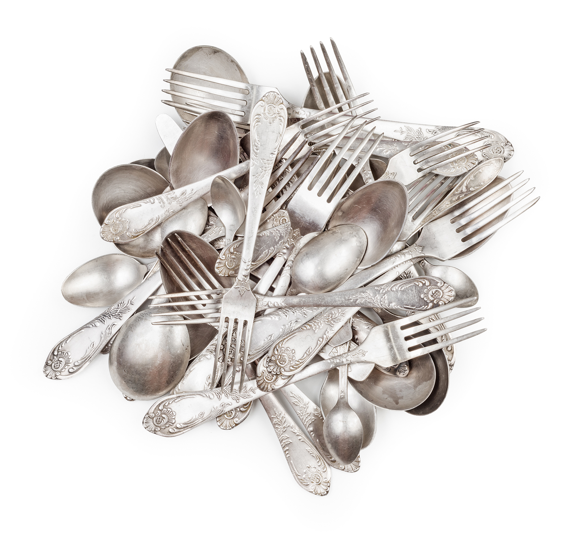 a messy pile of silver cutlery including forks, knives and spoons