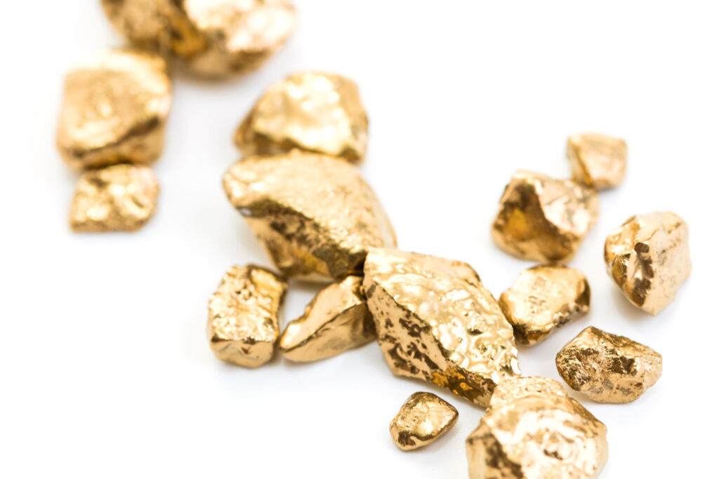 handful of gold nuggets close-up on a white background