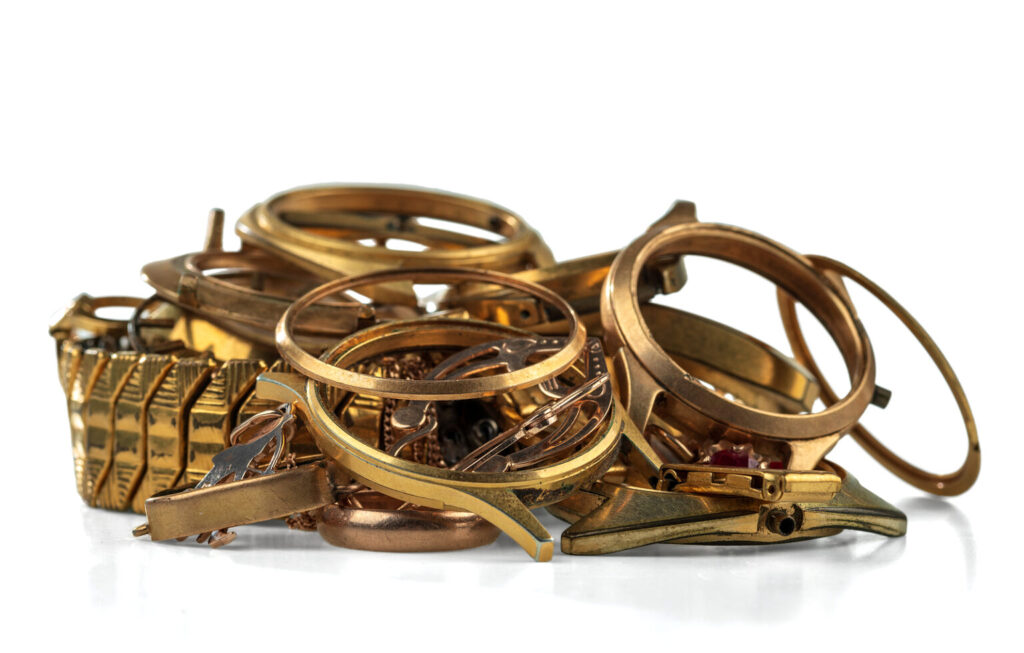 A scrap of gold. Old and broken jewelry, watches of gold and gold-plated isolated on a white background.